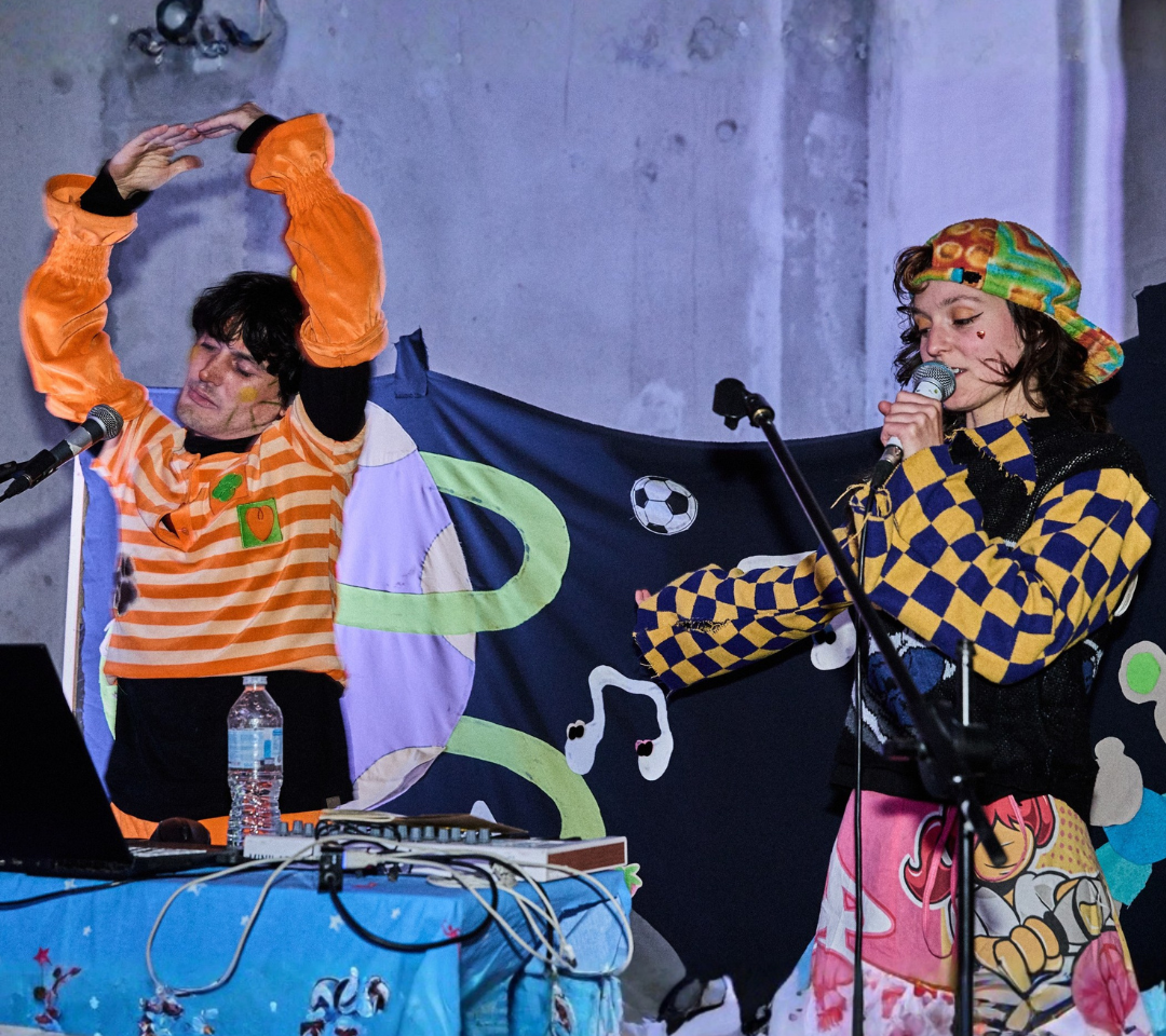 Blaise et Nico sur scène lors d'un concert, habillés comme dans leur clip Le Pépin, interprétant un morceau en duo